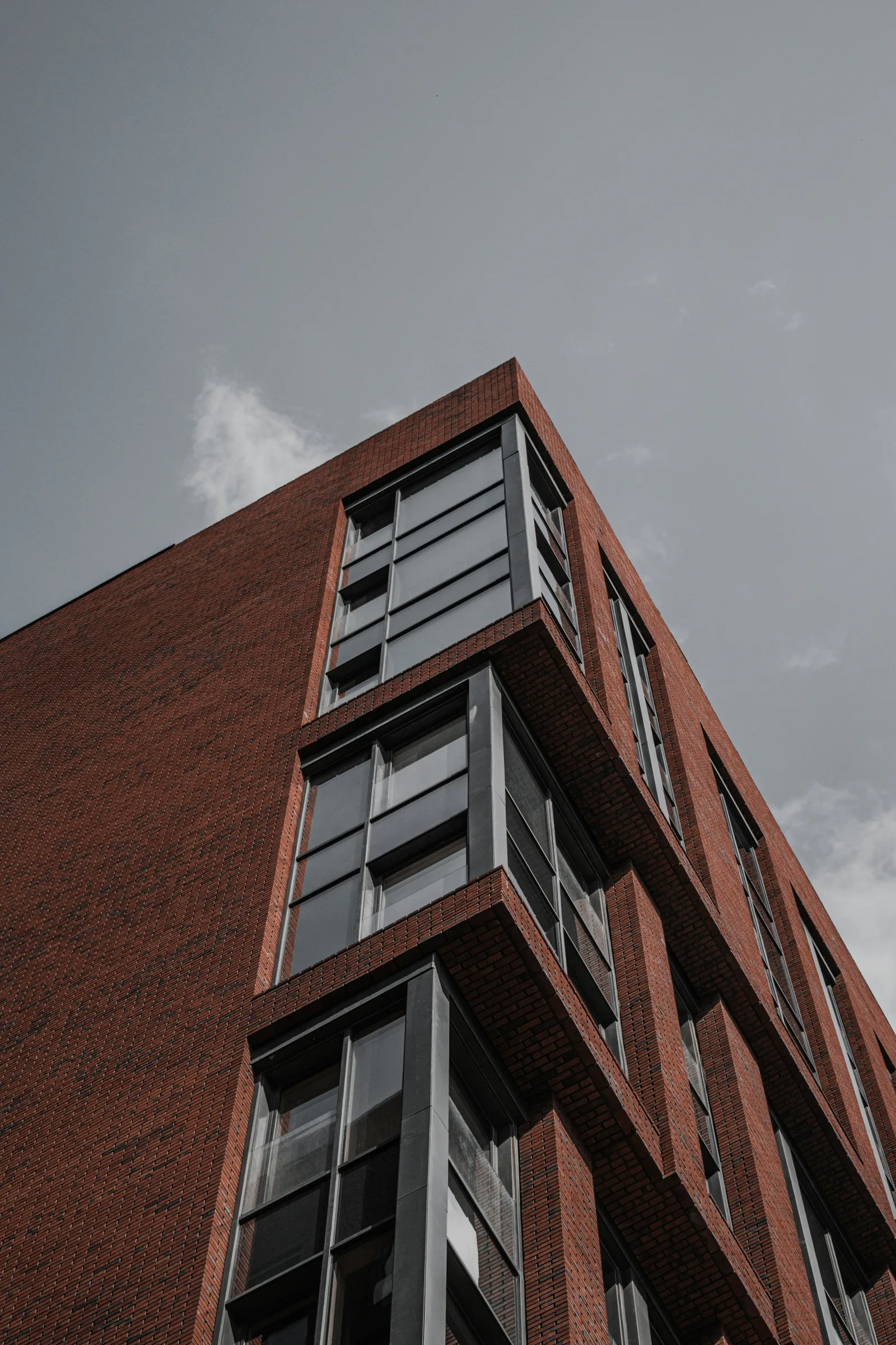 Corner of a red brick apartment block with stacked balconies