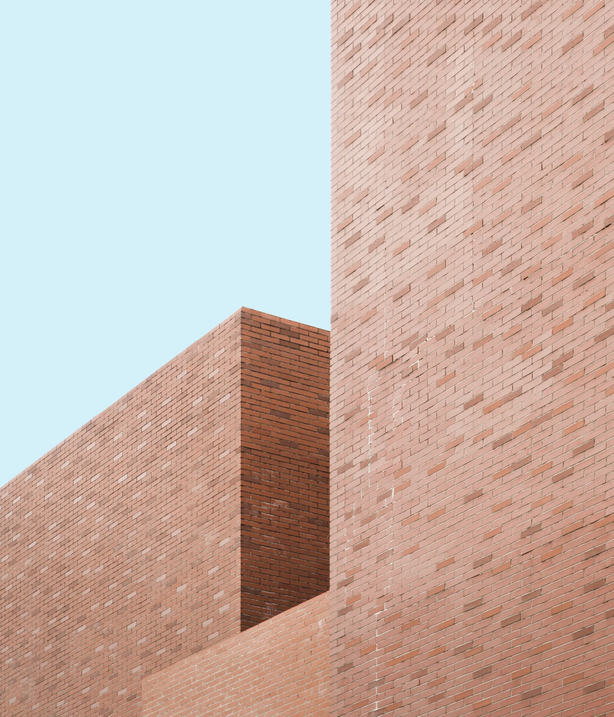 Two pale brick volumes against a clear sky