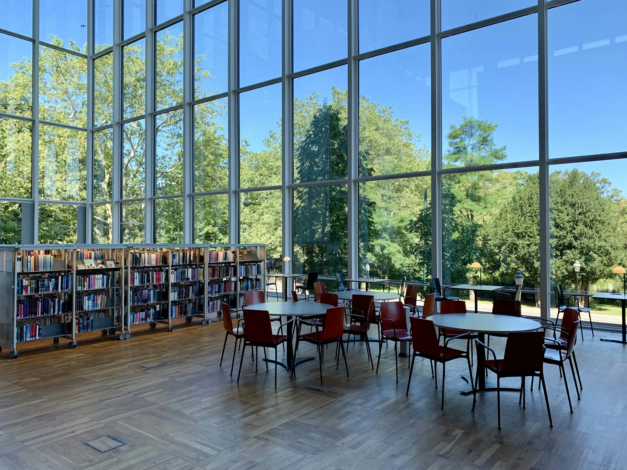 Reading room with tables beside a full-height glass wall