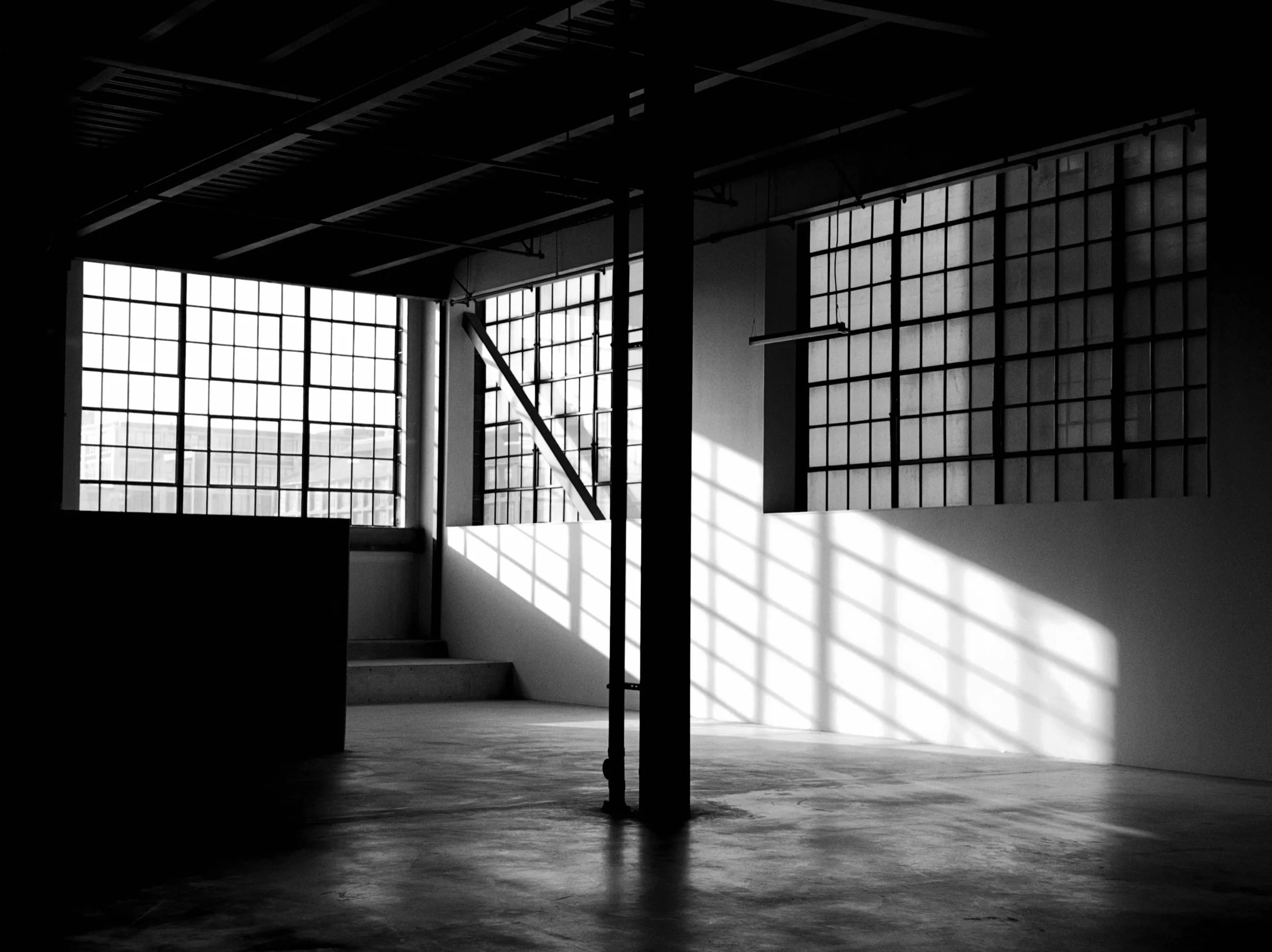 Tall factory windows casting sunlight across the studio floor