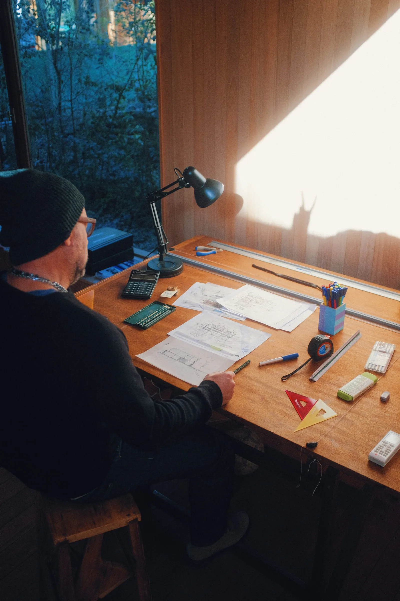 An architect drawing at a desk