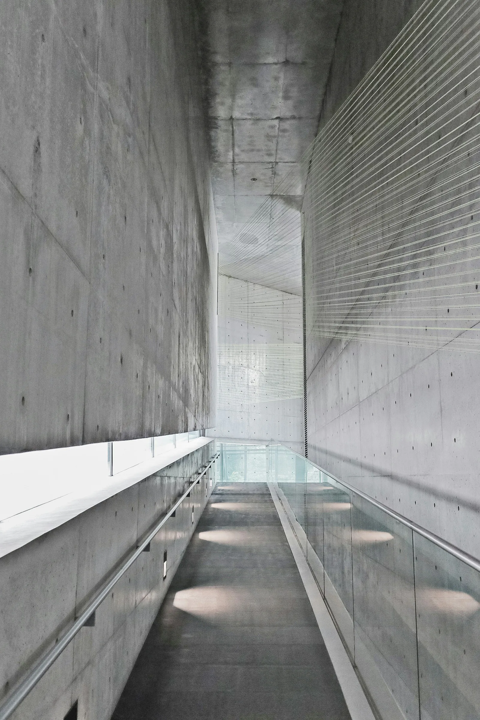 Narrow concrete passage lit from above
