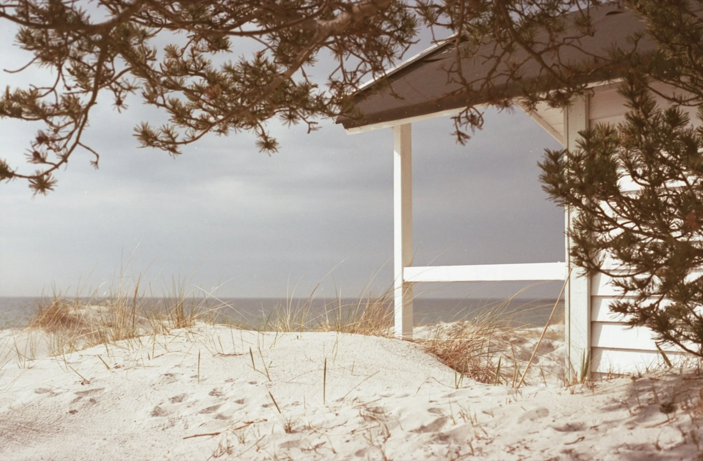 Covered porch looking out over white sand and dune grass
